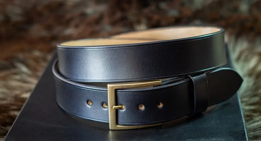 Ceinture en cuir noir à boucle en laiton, enroulée