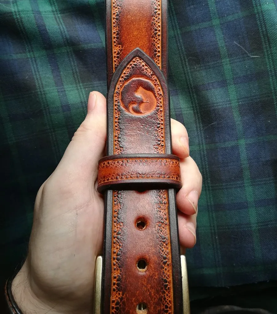Ceinture gravée marquée du tampon de l'atelier, tenue en main