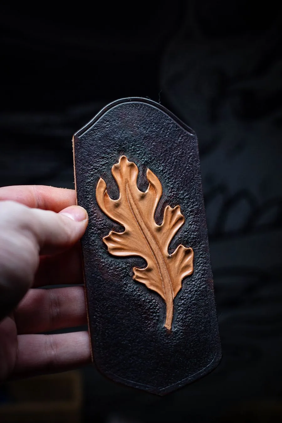 Étui noir orné d'une feuille de chêne repoussée en cuir naturel