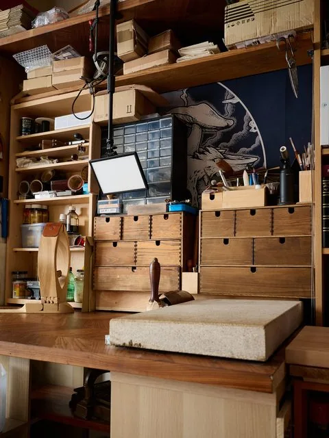 L'établi de l'atelier : plan de travail en bois, marbre à repousser, maillet et casiers à outils