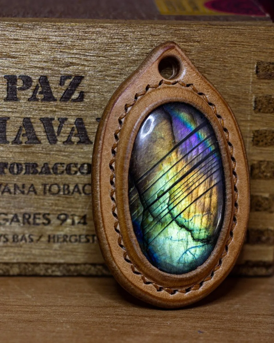Pendentif en cuir naturel cousu main, serti d’une labradorite ovale aux reflets bleus, verts et dorés