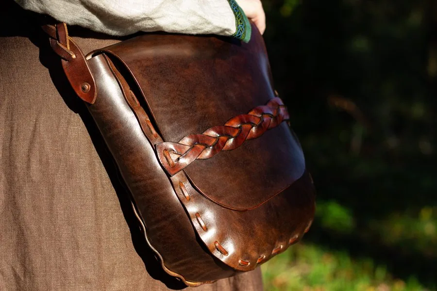 Sac en cuir brun à tresse, porté en bandoulière