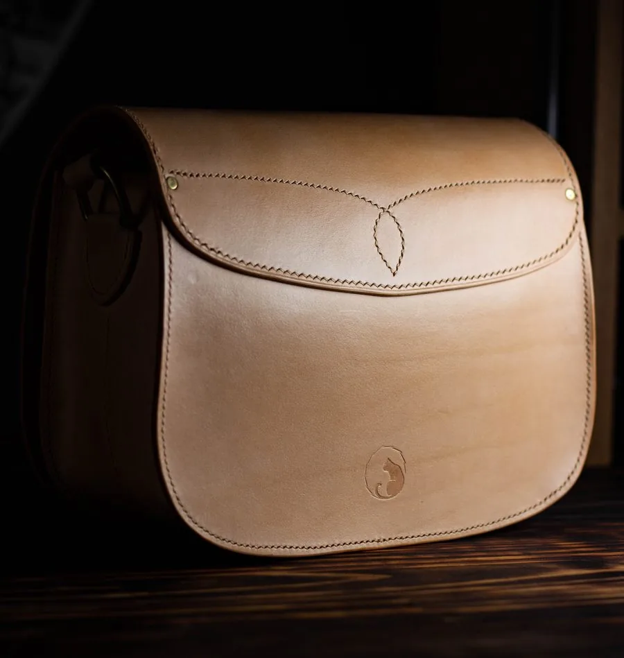 Sac en cuir naturel non teinté, marqué du tampon de l'atelier, sur fond sombre