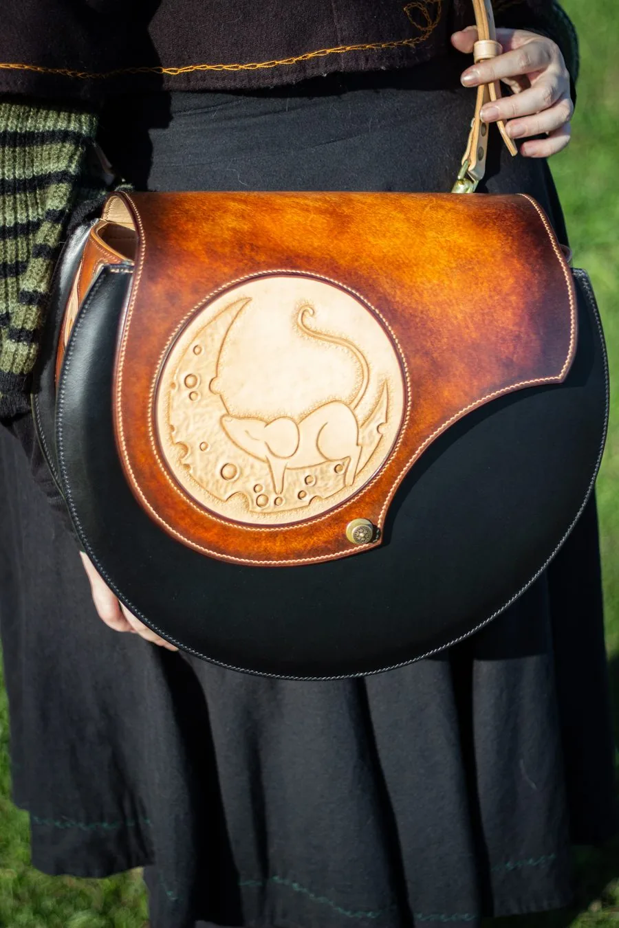 Sac rond en cuir noir et fauve, médaillon repoussé d'une souris, porté à l'épaule